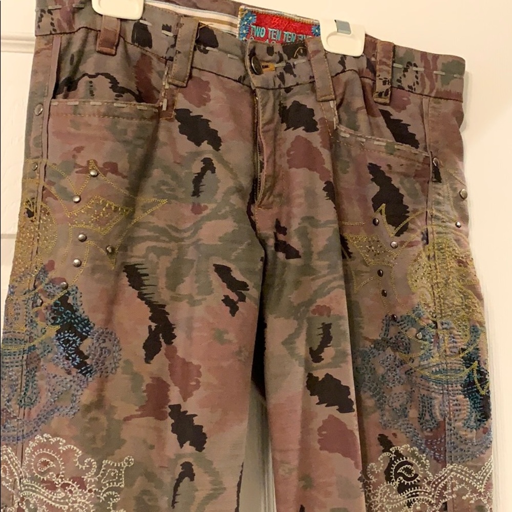 Camouflage jeans with metal grommets